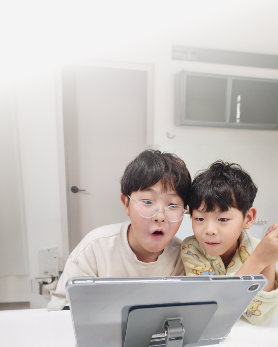 집에서 태블릿으로 수업을 듣는 아이들